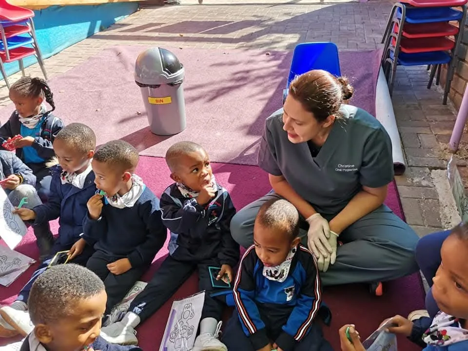 Christine with schoolchildren during community dental outreach